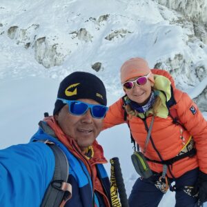 a man and woman taking a selfie while climbing a snowy mountain